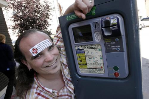 MIKE.DEAL@FREEPRESS.MB.CA 090818 Kelly Hughes owner of Aqua Books wants to know why the city hasn't bothered to put stickers on all the parking paystations downtown telling people that they have 2 hours of free parking on weekends. When he tried to put his own sticker on the paystations close to his bookstore, he was told that he would be ticketed for vandalism. WINNIPEG FREE PRESS
