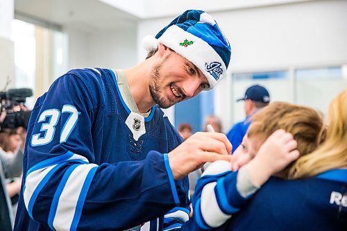 MIKAELA MACKENZIE / WINNIPEG FREE PRESS

Connor Hellebuyck signs jerseys at the Children's Rehab Centre for the Jets' annual holiday visit in Winnipeg on Monday, Dec. 9, 2019.  For Gabrielle Piche story.
Winnipeg Free Press 2019.