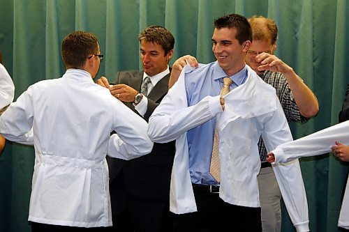 BORIS.MINKEVICH@FREEPRESS.MB.CA BORIS MINKEVICH / WINNIPEG FREE PRESS  090827 The University of Manitoba Faculty of Dentistry and School of Dental Hygiene White Coat ceremony at the Frederic Gaspard Hall of the Basic Medical Sciences Building. Entering Dentistry students (L-R) Nazariy Babyak and Benjamin Rogala put on the white coats with the help of their mentors Dentists Dr. Mark Scoville and Dr. Mike Sullivan.  29 dentistry and 26 dental hygiene students this year.
