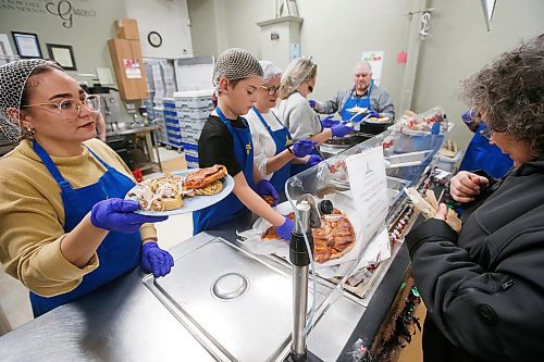 JOHN WOODS / WINNIPEG FREE PRESS
Lighthouse Mission volunteers serve up a lunch provided by Santa Lucia Pizza at the Main Street mission in Winnipeg Wednesday, December 25, 2019. 

Reporter: Belle