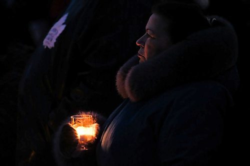 Daniel Crump / Winnipeg Free Press. A woman holds a candle at a vigil for Kelly Fraser. Hundreds of people attend the vigil at the Odena Circle Saturday evening. January 4, 2020.
