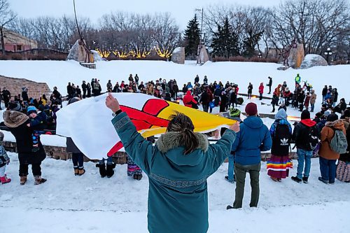 Daniel Crump / Winnipeg Free Press. A woman holds up the Inuit flag during a ceremony in memory of singer Kelly Fraser at the Odena Circle Saturday evening. January 4, 2020.