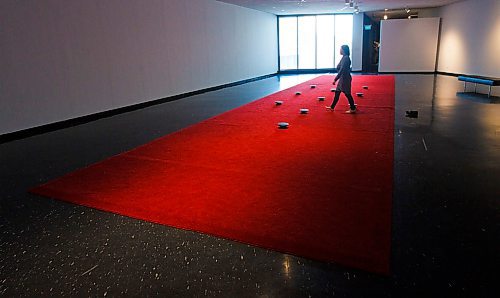 MIKE DEAL / WINNIPEG FREE PRESS
A person walks amongst the speakers in the red carpet of the Prayer exhibit by James Webb at the WAG. 
According to the WAG, "The work consists of recordings of prayer from individuals who belong to dozens of faiths and spiritual affinities in the host city. Listeners are invited to remove their shoes and walk the length of the carpet, composing their own arrangement of voices as they go, or to kneel or otherwise lower themselves next to a speaker to listen more closely to particular prayers."
200106 - Monday, January 06, 2020.