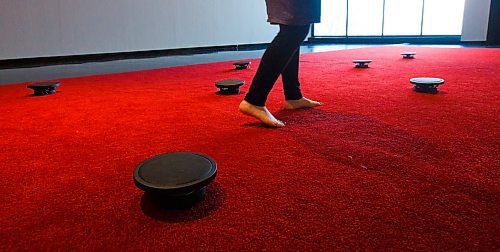 MIKE DEAL / WINNIPEG FREE PRESS
A person walks amongst the speakers in the red carpet of the Prayer exhibit by James Webb at the WAG. 
According to the WAG, "The work consists of recordings of prayer from individuals who belong to dozens of faiths and spiritual affinities in the host city. Listeners are invited to remove their shoes and walk the length of the carpet, composing their own arrangement of voices as they go, or to kneel or otherwise lower themselves next to a speaker to listen more closely to particular prayers."
200106 - Monday, January 06, 2020.