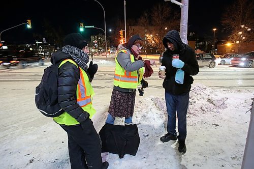 SHANNON VANRAES / WINNIPEG FREE PRESS
Lara Rae, a volunteer with the West Broadway Bear Clan Patrol, hands a man a contain of homemade garlic soup on the corner of Broadway and Sherbrook St. during a frigid Friday night patrol.