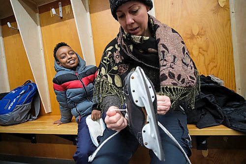 Daniel Crump / Winnipeg Free Press. Carol Reimer (right) helps Adonay Takeia (left) into a pair of skates as he gets ready to try skating for the first time during the True North Youth Foundation's Welcome to Winnipeg event at Camp Manitou. January 11, 2020.