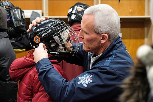 Daniel Crump / Winnipeg Free Press. A True North staff member helps a new comer put on her helmet as she gets set to go for a skate during the True North youth Foundation's Welcome to Winnipeg skating event at Camp Manitou. January 11, 2020.