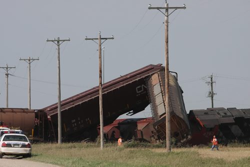Brandon Sun 04092009 Grain cars and locomotives from a CN train lie in a twisted wreck after the train struck a semi trailer at a railway crossing on Rd. 58 N south of Carberry, Man. on Friday morning. No one was injured in the accident which crushed the second rig of the double-long semi and derailed the train. (Tim Smith/Brandon Sun)