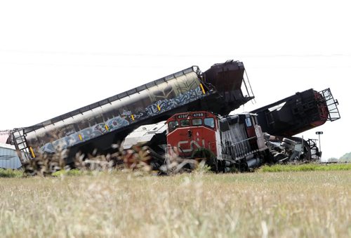 Brandon Sun 04092009 Grain cars and locomotives from a CN train lie in a twisted wreck after the train struck a semi trailer at a railway crossing on Rd. 58 N south of Carberry, Man. on Friday morning. No one was injured in the accident which crushed the second rig of the double-long semi and derailed the train. (Tim Smith/Brandon Sun)
