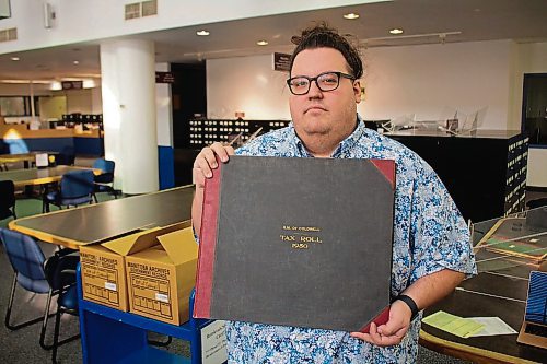 Canstar Community News Jan. 15, 2020 - David Parent, faculty member in the department of native tudies and history at the University of Manitoba, holding up a tax book from 1950. (JUSTIN LUSCHINSKI/CANSTAR COMMUNITY NEWS/METRO)