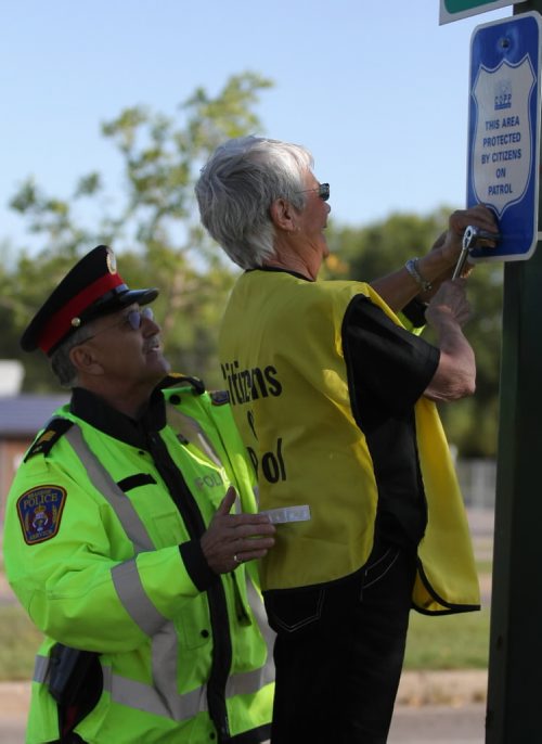 Brandon Sun Citizen On Patrol Program (COPP) volunteer Myrtle Hudson tightens the bolts on a new sign on Victoria Avenue along with Brandon Police Serivce COPP's liaison Staff Sgt. Larry Yanick on Wednesday morning. Eight signs, sponsored through Manitoba Public Insurance, will be going up at various entrances to Brandon. (Bruce Bumstead/Brandon Sun)