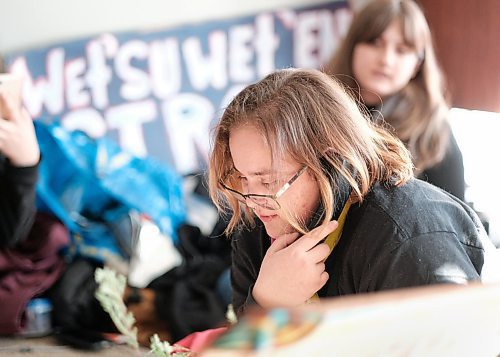 Mike Sudoma / Winnipeg Free Press
WetSuweten supporter, Carter Graveline (centre) talks on the phone with Minister of Northern Affairs, Dan Vandals office in Ottawa as they sit in at Vandals office in support of the WetSuwetEn peoples Thursday afternoon.
February 4, 2020