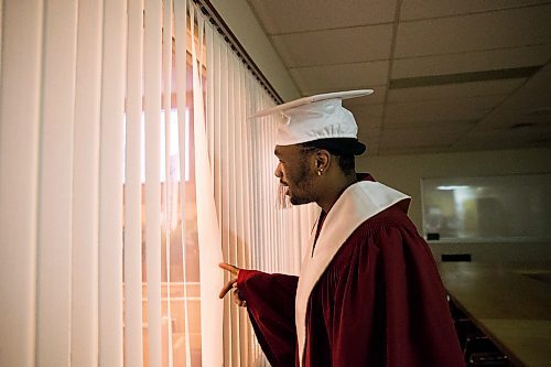 MIKAELA MACKENZIE / WINNIPEG FREE PRESS

Graduate Daniel Pembele peeks out to look at the crowd before the first-ever Freedom International School (a Christian private school for at-risk refugee students) graduation in Winnipeg on Friday, Feb. 7, 2020.  For Maggie Macintosh story.
Winnipeg Free Press 2019.