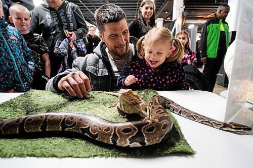 Daniel Crump / Winnipeg Free Press. Devin Church (right) holds his Two-year-old daughter Octavia Church (right) who reacts after touching a bearded dragon. The reptiles were on display Saturday afternoon as part of Love Your Pet Day at Assiniboia Downs. February 8 , 2020.