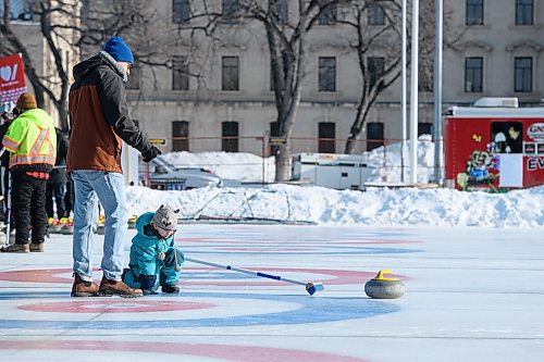 Mike Sudoma / Winnipeg Free Press
Oleg Chopy helps his son Darik as he curls for the first time during the Ironman Outdoor Curling Bonspiel on Memorial Blvd Sunday morning
February 9, 2020