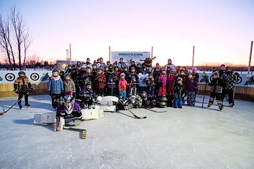 Daniel Crump / Winnipeg Free Press. The Glawson family, players from the A2 Atom River East Royals teams, and members of the community pose for a big group photo on the Glawsons backyard rink. February 10, 2020.