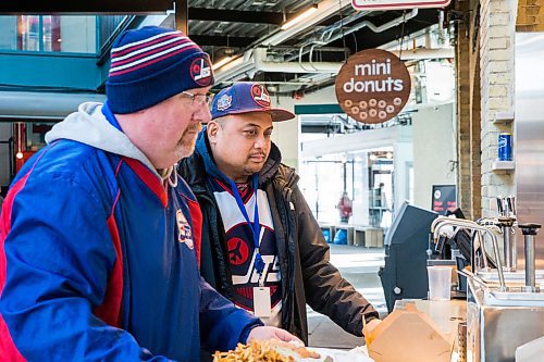 MIKAELA MACKENZIE / WINNIPEG FREE PRESS

David Hallick (left) and Nate Imperial get condiments for their food at Wienerpeg, the new gourmet hot dog vendor at The Forks, in Winnipeg on Tuesday, Feb. 11, 2020. For biz story.
Winnipeg Free Press 2019.