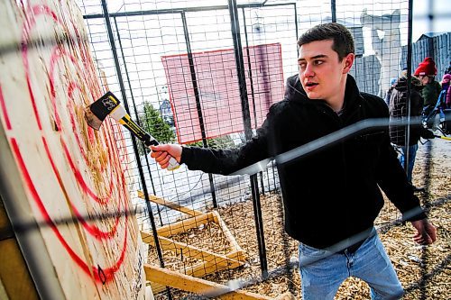 Daniel Crump / Winnipeg Free Press. Justin Duguid retrieves his axe after nailing a bullseye at the axe throwing venue at Festival du Voyageur. February 15, 2020.