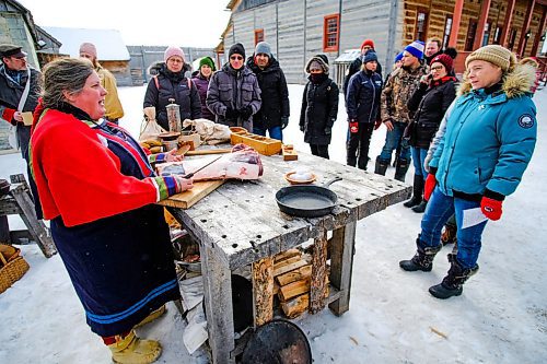 Daniel Crump / Winnipeg Free Press. Kiri Butter (left), from Thunder Bay, demonstrates how to prepare cured meat to onlookers at Festival du Voyageur Saturday afternoon. February 15, 2020.
