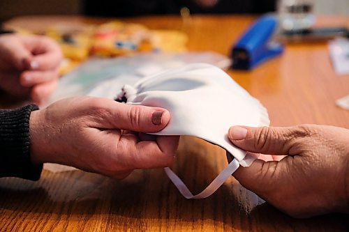 Daniel Crump / Winnipeg Free Press. Seamstress Vicky Isliefson (left) holds a baby bonnet that she is working on. February 8, 2020.