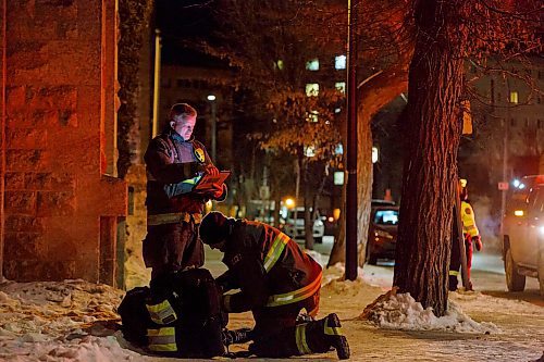 MIKE DEAL / WINNIPEG FREE PRESS
WFPS Lieutenant Darrell Desjardins takes notes while Neil McKinlay checks on a man laying in the snow by Central Park Friday evening.
200221 - Friday, February 21, 2020.