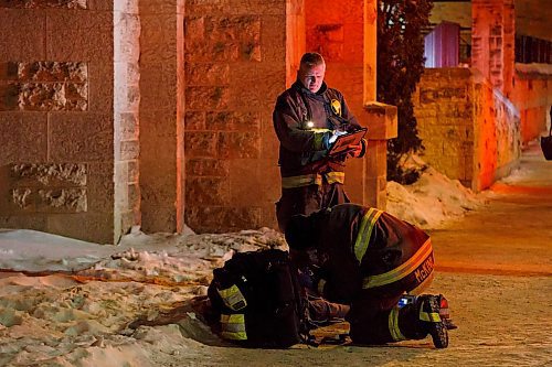 MIKE DEAL / WINNIPEG FREE PRESS
WFPS Lieutenant Darrell Desjardins takes notes while Neil McKinlay checks on a man laying in the snow by Central Park Friday evening.
200221 - Friday, February 21, 2020.