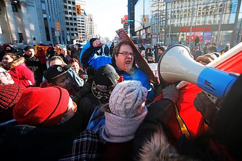 JOHN WOODS / WINNIPEG FREE PRESS
A person, centre, speaking out against protesters in support of Wetsuweten blockades who closed Portage and Main to traffic in Winnipeg Wednesday, February 26, 2020 is surrounded. 

Reporter: ?