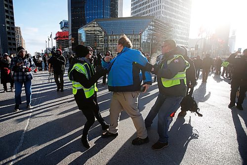 JOHN WOODS / WINNIPEG FREE PRESS
A person speaking out against protesters in support of Wetsuweten blockades who closed Portage and Main to traffic in Winnipeg Wednesday, February 26, 2020 is removed by police after getting surrounded by protesters. 

Reporter: ?