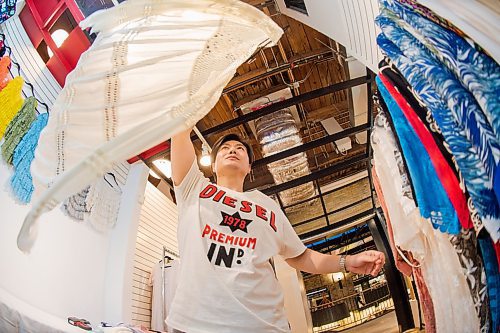 Mike Sudoma / Winnipeg Free Press
Clothing Designer, Dennis Wang, hangs a dress on a clothing rack as he kicks of the grand opening of his pop up shop on the second floor of the Forks Market Friday evening
February 28, 2020