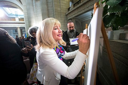 MIKAELA MACKENZIE / WINNIPEG FREE PRESS

Cathy Cox, minister responsible for the status of women, writes the name of a woman who inspires her (her Baba) on a canvas at the Manitoba Legislative Building in Winnipeg on International Women's Day, Monday, March 9, 2020. 
Winnipeg Free Press 2019.