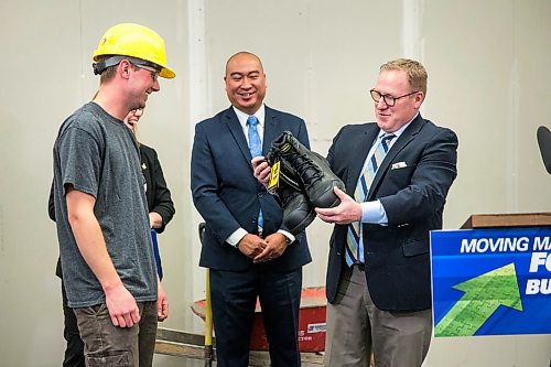 MIKAELA MACKENZIE / WINNIPEG FREE PRESS

Finance minister Scott Fielding (right) hands a pair of new steel-toed work boots to apprentice carpenter Jaycek Valentine as MLA Jon Reyes watches the day before the 2020 provincial budget at Fort Richmond Collegiate in Winnipeg on Tuesday, March 10, 2020. For Larry Kusch story.
Winnipeg Free Press 2019.