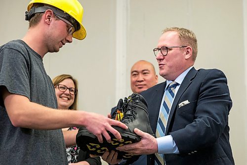 MIKAELA MACKENZIE / WINNIPEG FREE PRESS

Finance minister Scott Fielding (right) hands a pair of new steel-toed work boots to apprentice carpenter Jaycek Valentine as minister Sarah Guillemard (back left) and MLA Jon Reyes watch the day before the 2020 provincial budget at Fort Richmond Collegiate in Winnipeg on Tuesday, March 10, 2020. For Larry Kusch story.
Winnipeg Free Press 2019.