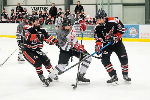 Daniel Crump / Winnipeg Free Press.¤A Glenlawn player (white) tries to split the College Beliveau defence as the Lions take on the Barracudas in game two of the A Division High School Hockey Championships. March 10, 2020.