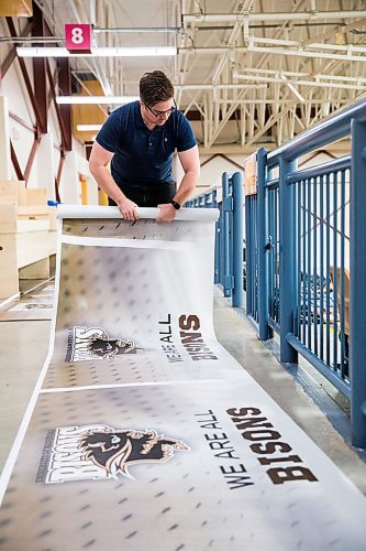 MIKAELA MACKENZIE / WINNIPEG FREE PRESS

John Gaudes, sports information and digital media coordinator for the Bisons, rolls up a banner at the Investors Group Athletic Centre after the cancellation of the mens volleyball championship due to COVID-19 in Winnipeg on Friday, March 13, 2020. 
Winnipeg Free Press 2019.