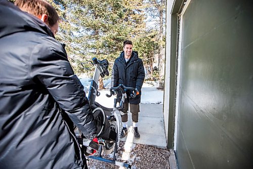 MIKAELA MACKENZIE / WINNIPEG FREE PRESS

Taylor Renaud, owner of Wheelhouse Cycle Club (right), and Casey Lanxon-Whitford, motivator at Wheelhouse Cycle Club, carry a stationary bike to a client's home in Winnipeg on Wednesday, March 18, 2020. The gym is dropping off bikes at people's houses to borrow during the COVID-19 pandemic.
Winnipeg Free Press 2020