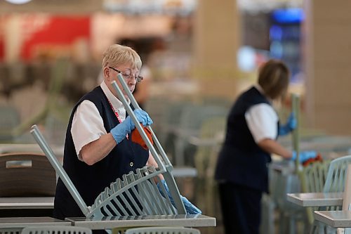 SHANNON VANRAES / WINNIPEG FREE PRESS
Staff at CF Polo Park clean chairs in the mall's food court on March 18, 2020. While the mall remains open, most stores are closed due to COVID-19 and tables and chairs are off limits to visitors.