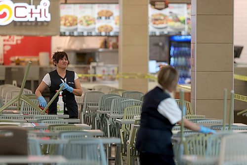 SHANNON VANRAES / WINNIPEG FREE PRESS
Staff at CF Polo Park clean chairs in the mall's food court on March 18, 2020. While the mall remains open, most stores are closed due to COVID-19 and tables and chairs are off limits to visitors.