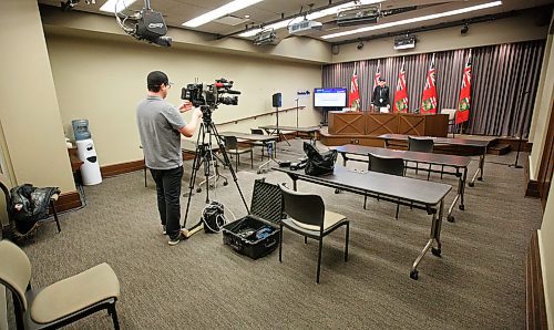 MIKE DEAL / WINNIPEG FREE PRESS
A CBC camera person sets up his gear, acting as the pool video provider for the COVID-19 update briefing in Room 68 of the Manitoba Legislative building monday morning. His footage will be transmitted to all the other television stations. 
The briefings have now moved to a very restricted media Pool system. One TV cameraperson and one still photographer. Reporters can ask questions via a conference call.
200323 - Monday, March 23, 2020.