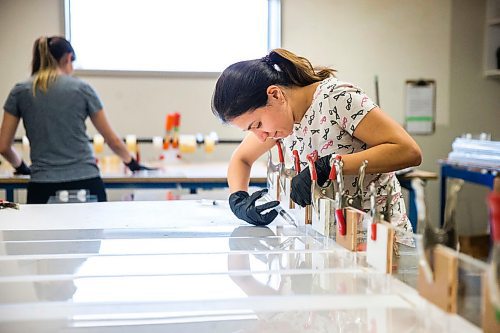 MIKAELA MACKENZIE / WINNIPEG FREE PRESS

Jeanne Diniz glues cough guard parts together at Acryl Design in Winnipeg on Monday, March 23, 2020. For Malak Abas story.
Winnipeg Free Press 2020