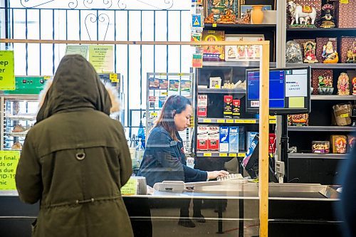 MIKAELA MACKENZIE / WINNIPEG FREE PRESS

May Peralta serves customers through a cough guard at Dino's Grocery Mart in Winnipeg on Monday, March 23, 2020. For Malak Abas story.
Winnipeg Free Press 2020