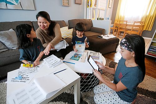 JOHN WOODS / WINNIPEG FREE PRESS
Jennifer Valencia home schools her children Jiahna, 6, Jian, 7, and Jyzella, 9, in their Elmwood home in Winnipeg Tuesday, March 24, 2020. School divisions are grappling with how to handle the digital divide as they promote online learning during satellite school. Some are sending home laptops, others are sticking to paper packages. The Valencia family is focused on paper work. Valencia says they only have one slow desktop, so she's been printing out all their assignments.

Reporter: macintosh