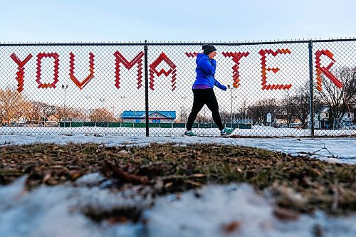 Daniel Crump / Winnipeg Free Press.¤A person walks past a work of street art that reads YOU MATTER on a fence near Earl Grey School in Fort Rouge Wednesday evening. March 25, 2020.