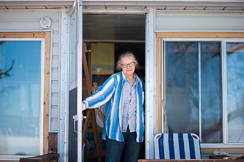 MIKAELA MACKENZIE / WINNIPEG FREE PRESS

Ainslie Davis, Sandy Hook based painter, poses for a portrait in the back doorway of her home (where she paints in the winter with a view of the lake) on Sunday, March 29, 2020. 
Winnipeg Free Press 2020