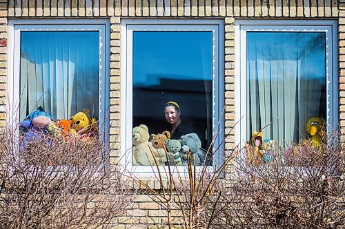 MIKAELA MACKENZIE / WINNIPEG FREE PRESS

Sheilah Restall, who sparked a new initiative called the Great Winnipeg Bear Hunt, poses for a portrait in her front window in Winnipeg on Monday, March 30, 2020. She's encouraging Winnipeggers to put teddy bears in their windows to give kids something to hunt for on neighbourhood walks.
Winnipeg Free Press 2020