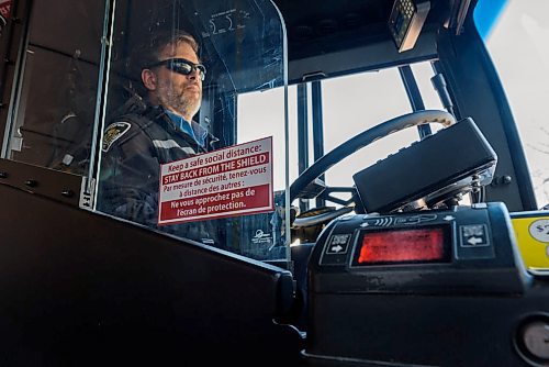 JESSE BOILY / WINNIPEG FREE PRESS
Bill Hadden, a transit driver, drives a bus down Portage Ave behind a protective pelxiglass on Monday, March 30, 2020. Many riders are trying to keep their distance between each other as social distancing is practiced during the current pandemic. 
Reporter: Eva Wasney