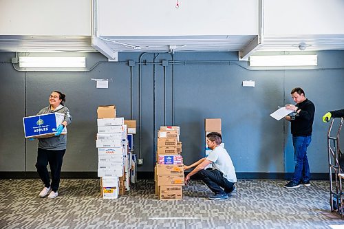 MIKAELA MACKENZIE / WINNIPEG FREE PRESS

Volunteers Tempest Bruce (left), Sam Trout, and Kyle Muswagon check out a food delivery before putting together emergency kits with food, hygiene and baby products at Ma Mawi Wi Chi Itata in Winnipeg on Monday, March 30, 2020. For Eva Wasney story.
Winnipeg Free Press 2020