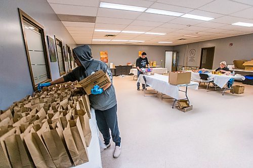 MIKAELA MACKENZIE / WINNIPEG FREE PRESS

Volunteer Tempest Bruce puts juice, snacks, and fruit into meal packages for emergency kits with food, hygiene and baby products at Ma Mawi Wi Chi Itata in Winnipeg on Monday, March 30, 2020. For Eva Wasney story.
Winnipeg Free Press 2020