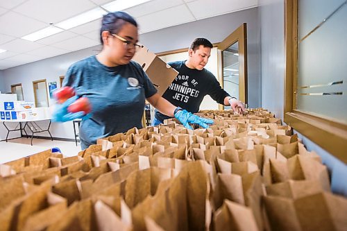 MIKAELA MACKENZIE / WINNIPEG FREE PRESS

Volunteers Kyle Muswagon (right) and Tempest Bruce put sandwiches, juice, snacks, and fruit into meal packages for emergency kits with food, hygiene and baby products at Ma Mawi Wi Chi Itata in Winnipeg on Monday, March 30, 2020. For Eva Wasney story.
Winnipeg Free Press 2020