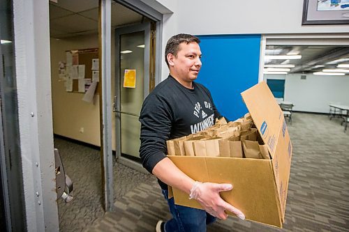 MIKAELA MACKENZIE / WINNIPEG FREE PRESS

Volunteer Kyle Muswagon brings meal packages out to go into emergency kits with food, hygiene and baby products at Ma Mawi Wi Chi Itata in Winnipeg on Monday, March 30, 2020. For Eva Wasney story.
Winnipeg Free Press 2020