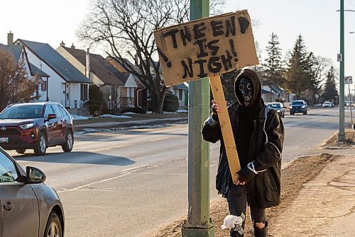 JESSE BOILY / WINNIPEG FREE PRESS
Local film maker Liam Flamand wears a gas mask and sports a sign that says The end is nigh, on Mountain Ave. on Monday, March 30, 2020. Flamand explained that he was doing it as guerrilla marketing for his upcoming film, and that it ties well with current events. 
Reporter: n/a